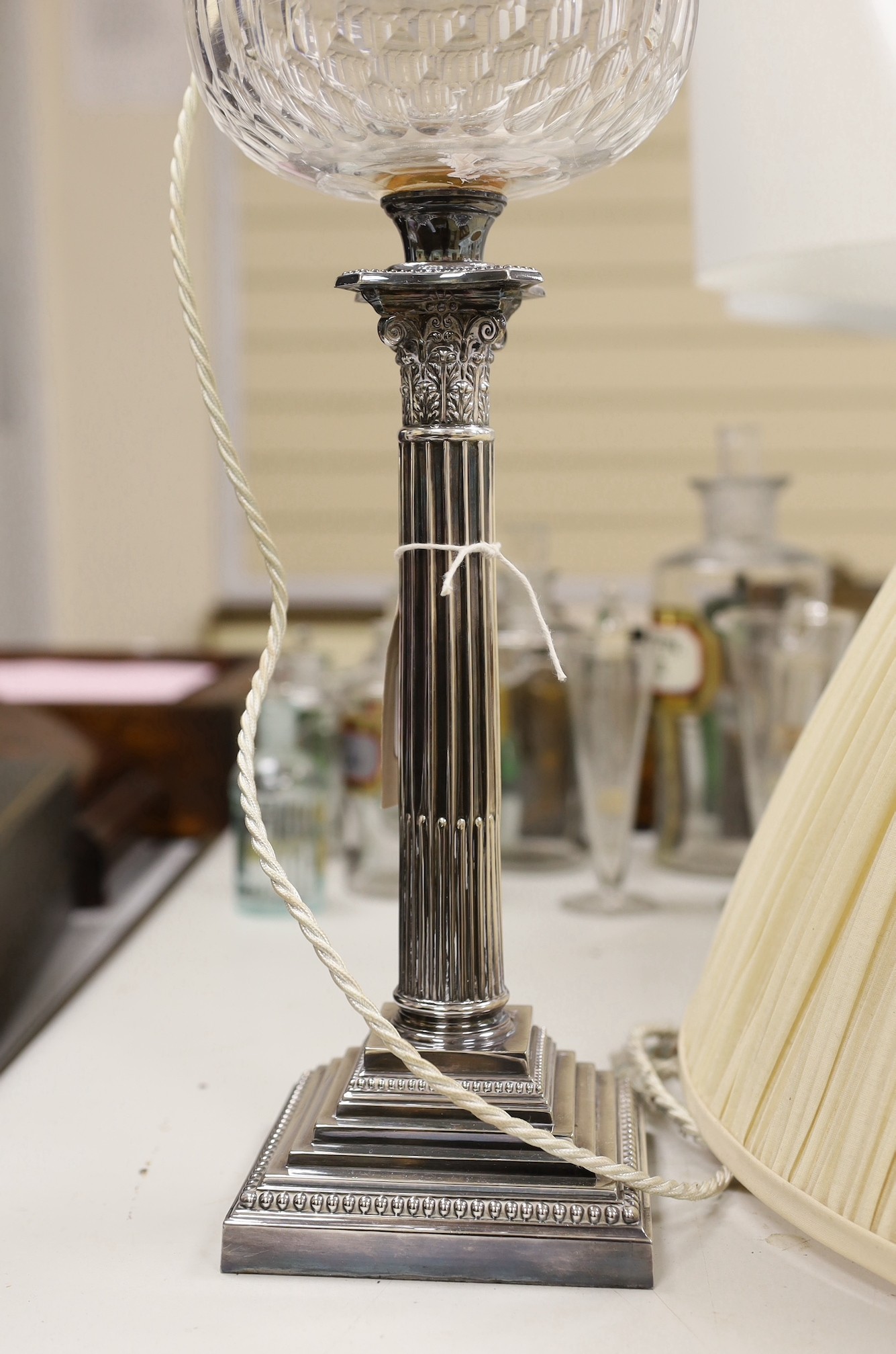 A Walker & Hall silver plated Corinthian column oil lamp converted to electricity as a lamp base, 49cms including light fitting